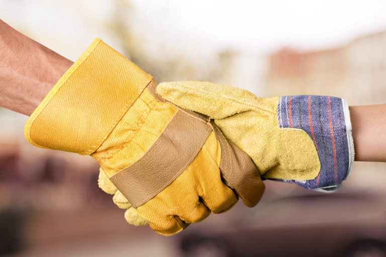 Shaking hands wearing work gloves