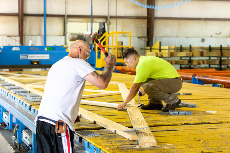 Two workers assembling a truss